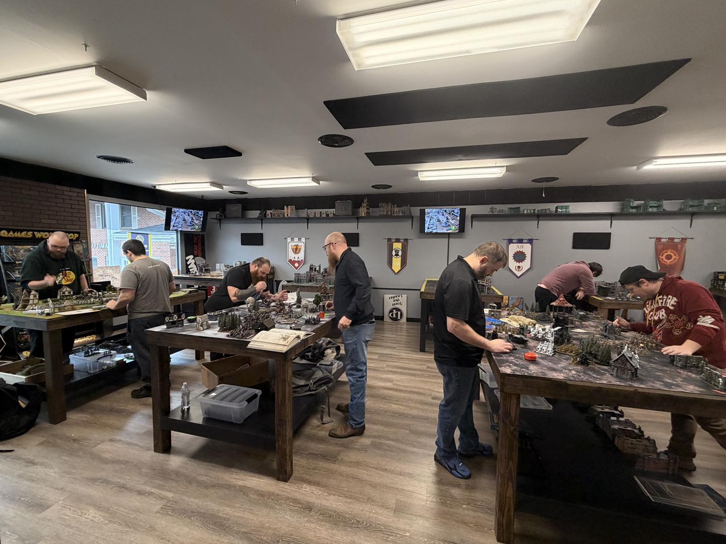 Busy wargaming tables full of players and detailed miniatures at Fenris Gaming Hall